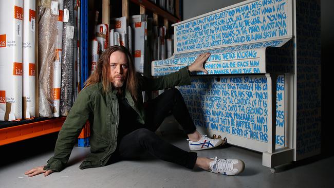 Singer, songwriter and composer Tim Minchin with his one-of-a-kind ‘Airport Piano’, which will be auctioned for the Art of Music charity fundraiser on Saturday July 17 at the Art Gallery of NSW. Picture: Jane Dempster