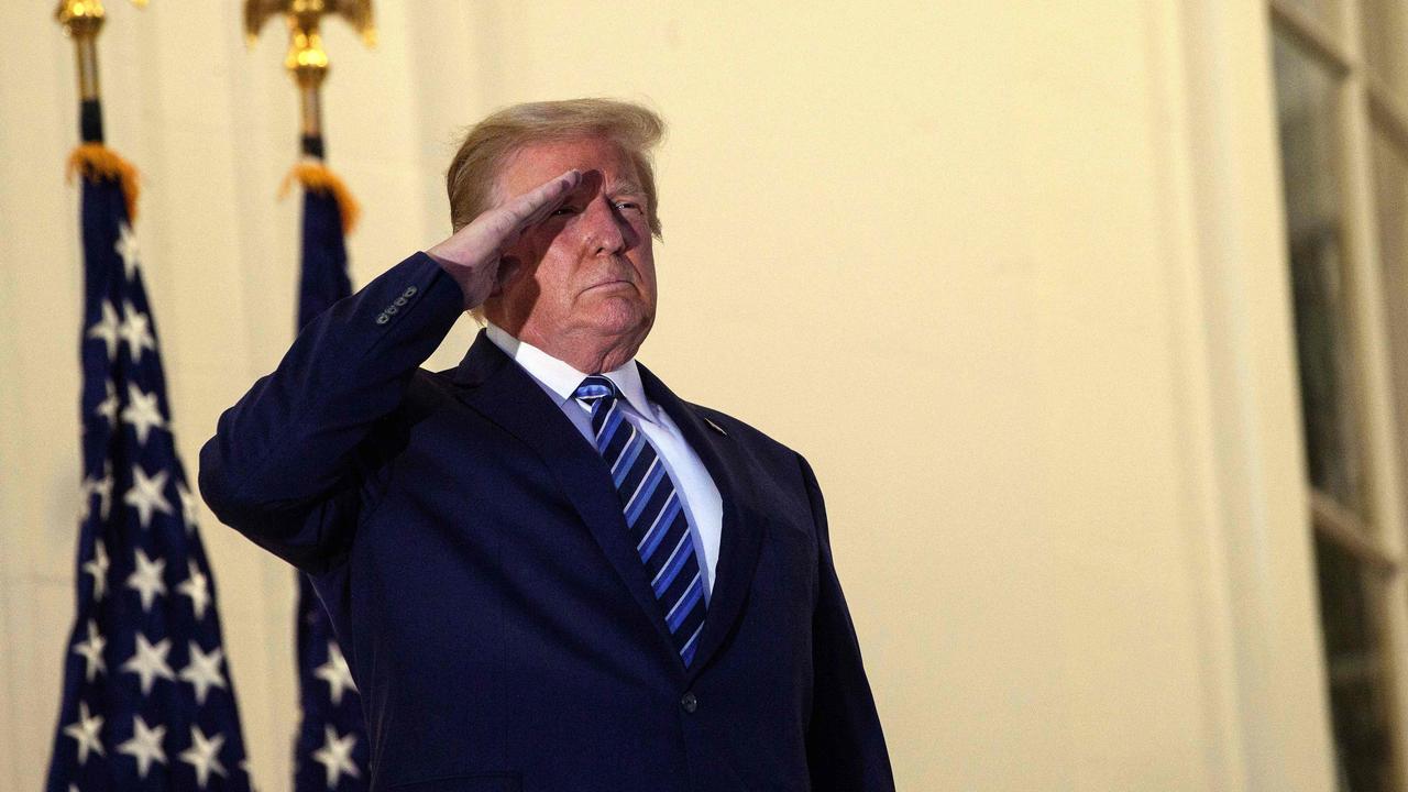 President Donald Trump salutes from the Truman Balcony upon his return to the White House from Walter Reed medical centre on Monday. Picture: Nicholas Kamm/AFP