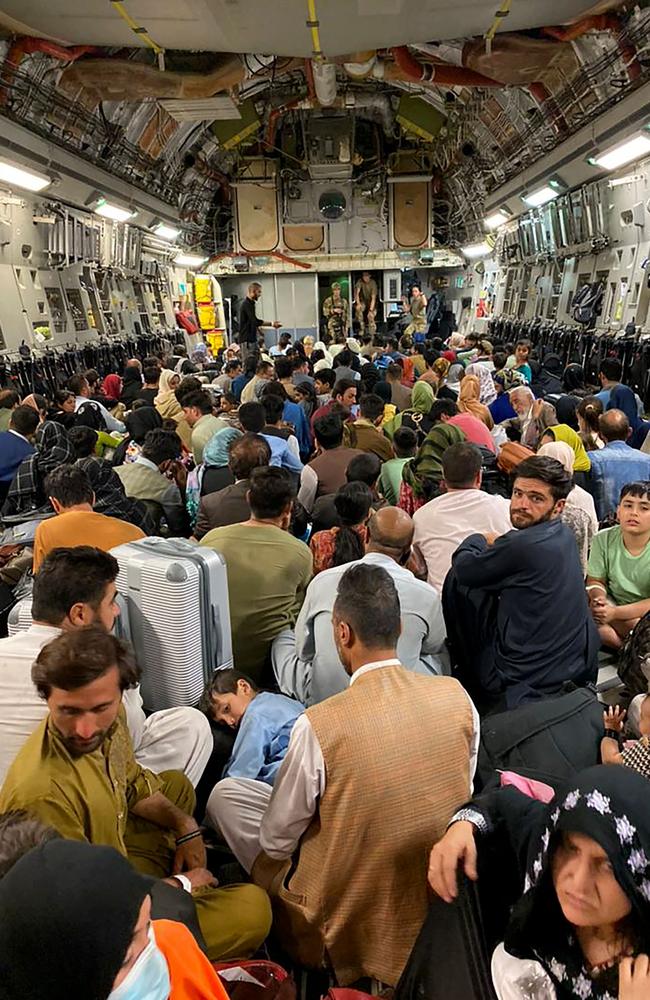 Afghan people sit inside a US military aircraft to leave Afghanistan, at the military airport in Kabul on August 19 after the Taliban's military takeover. Picture: AFP