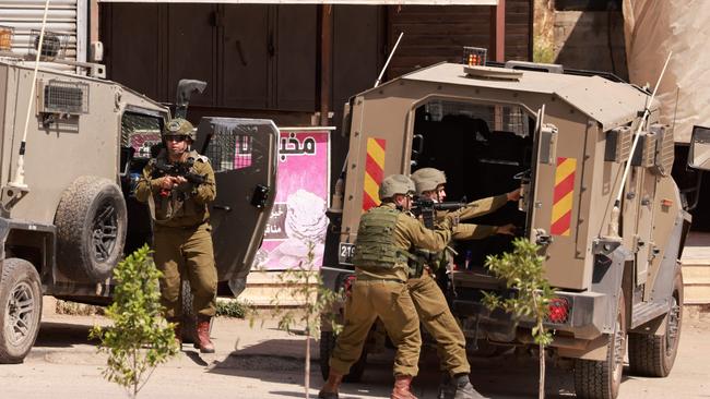 Israeli forces take a position in a street during a raid in the al-Faraa refugee camp in the occupied West Bank. Picture: AFP.