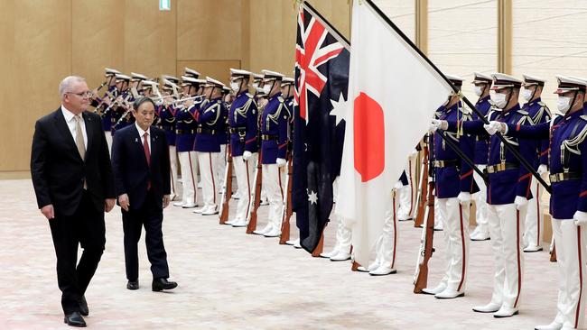 Scott Morrison and Yoshihide Suga inspect an honour guard as part of a welcome ceremony in Tokyo. Picture: AFP