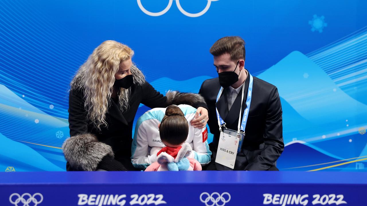 Kamila Valieva reacts to her score with choreographer Daniil Gleikhengauz and coach Eteri Tutberidze. (Photo by Matthew Stockman/Getty Images)