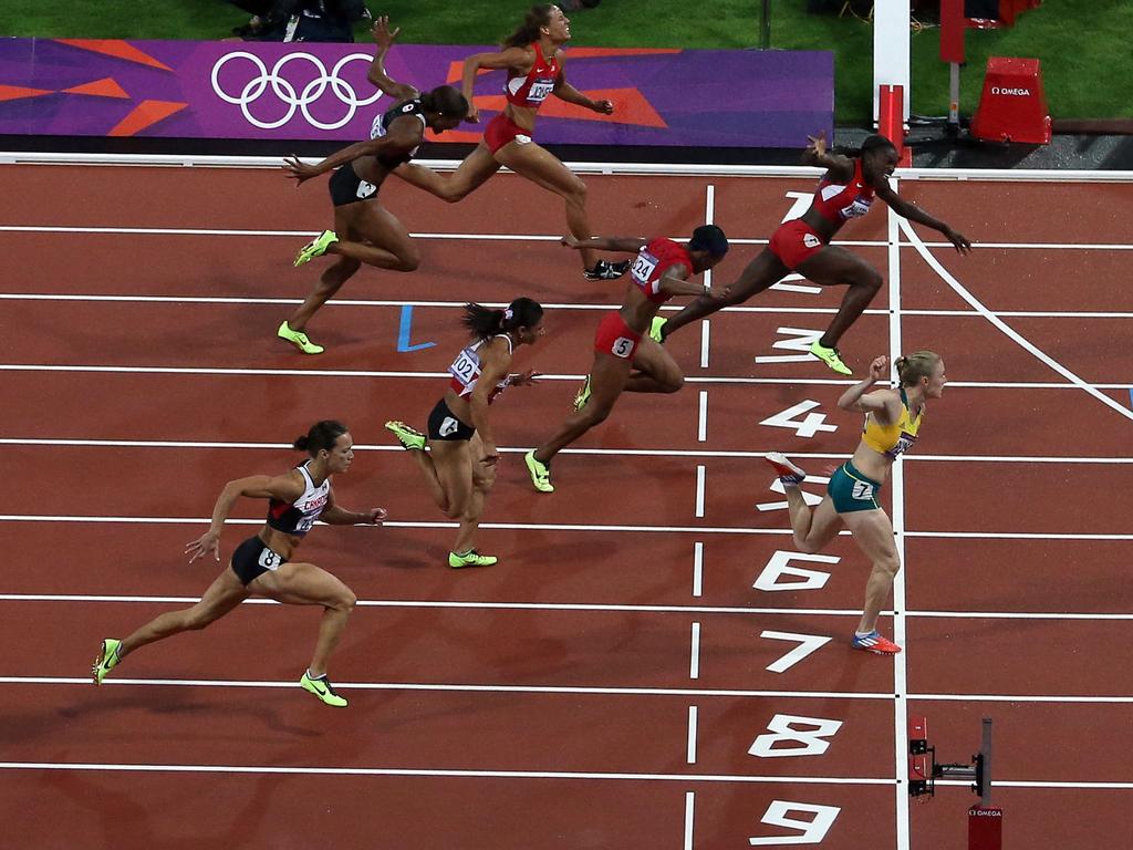 Sally Pearson dips on the line to win gold ahead of Dawn Harper during the 100 metre hurdles final in London. Picture: Dave Thompson/PA Wire