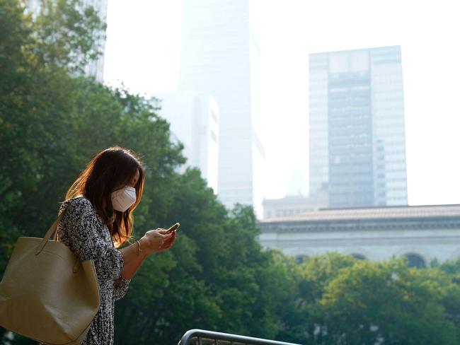 A woman wears a mask in Bryant Park New York City, as smoke from wildfires in Canada continue to affect the city, forcing the closure of schools. Picture: AFP