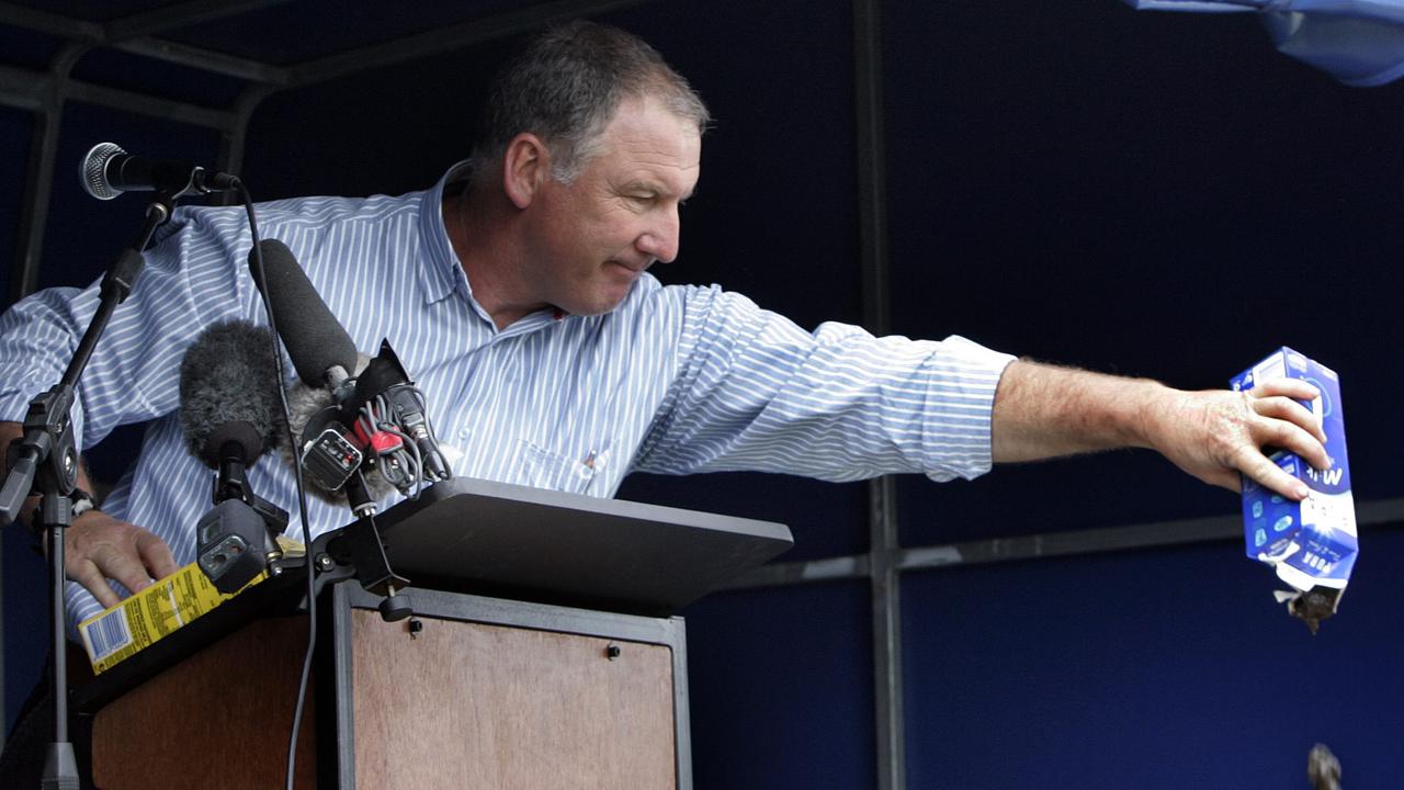 Protest Rally at Devonport by dairy farmers against multi-national milk processor National Foods, rally organiser Richard Bovill pours mud out of a Pura milk carton to demonstrate a point while speaking at the rally