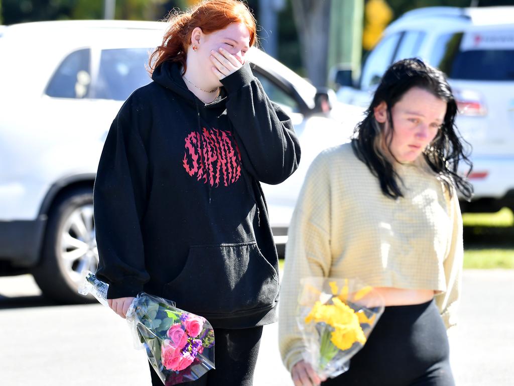 Family and friends bring flowers to the scene in Caboolture where a woman in her 20s was fatally stabbed overnight. A man is in custody following a police pursuit. Picture: John Gass