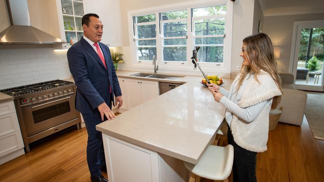 Real estate agent John McManus being filmed by his daughter Morgan for a virtual inspection in Sydney. Picture: AAP