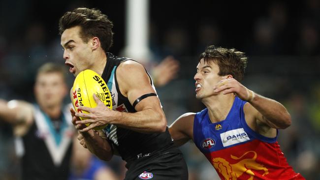 Jarryd Lyons, pictured tackling Port’s Karl Amon, was the dominant midfielder on the ground. Picture: Daniel Pockett/Getty