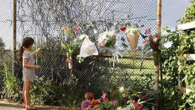 Floral tributes have been placed on a pathway leading to Little Bay. Picture: Richard Dobson