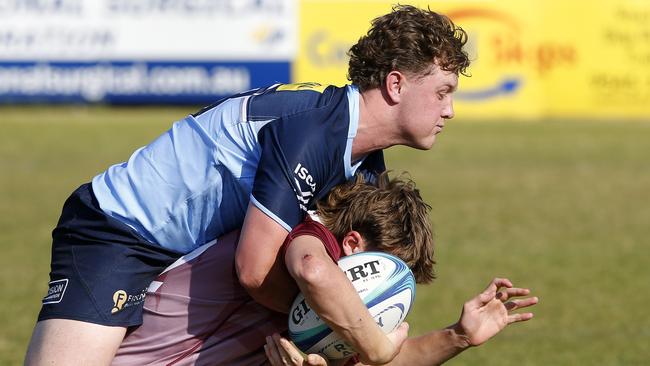 Waratahs' Tom Klem tackles Qld Reds' Jacob Johnson in the recent under 18s battle. Players at the Gen Blue Cup are chasing selection in the team to take on the under 15s Reds team.