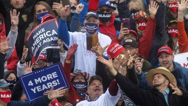 Trump supporters strain to catch a Make America Great Again hat thrown by Donald Trump during in Lititz, Pennsylvania, on Wednesday. Picture: AFP