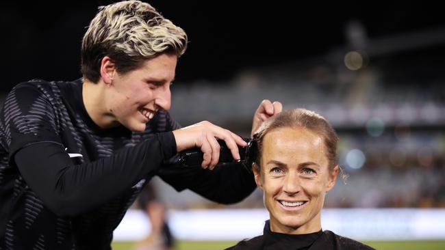 Aivi Luik of the Matildas has her head shaved by Rebekah Stott of New Zealand