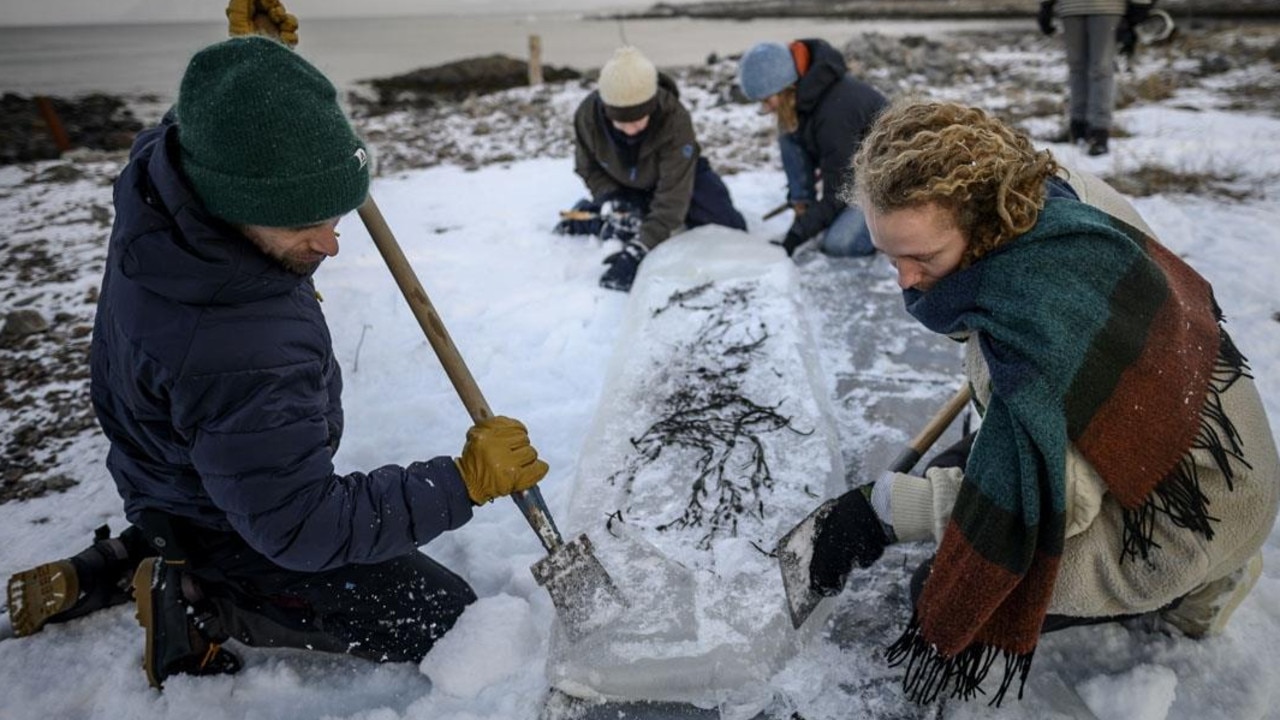 Mattias Hornquist and Pontus Hallin shape a board out of ice. Picture: AFP