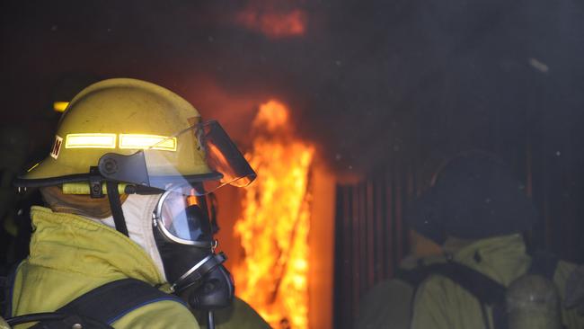 Garry Branson looks on as the timber catches fire in the training cell.