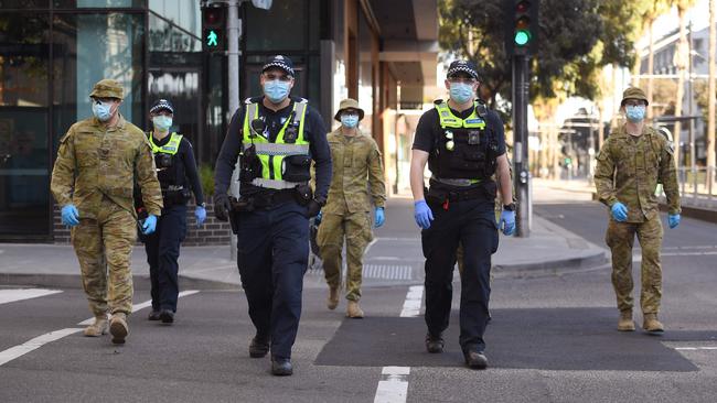 A group of police and soldiers patrol Docklands on August 2. Photo: AFP