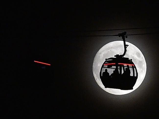 The moon rises behind a car on the The Emirates Air Line (cable car) in London’s Docklands on November 13, 2016. Tomorrow, the moon will orbit closer to the earth than at any time since 1948, named a ‘supermoon’, it is defined by a Full or New moon coinciding with the moon’s closest approach to the Earth. Picture: AFP PHOTO / Glyn KIRK