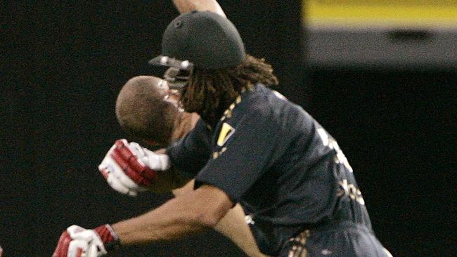 Australia's Andrew Symonds shoulder charges a pitch invader (streaker) to the ground during the second final of their Tri-Nations one day international cricket series against India at Brisbane, March 4, 2008.