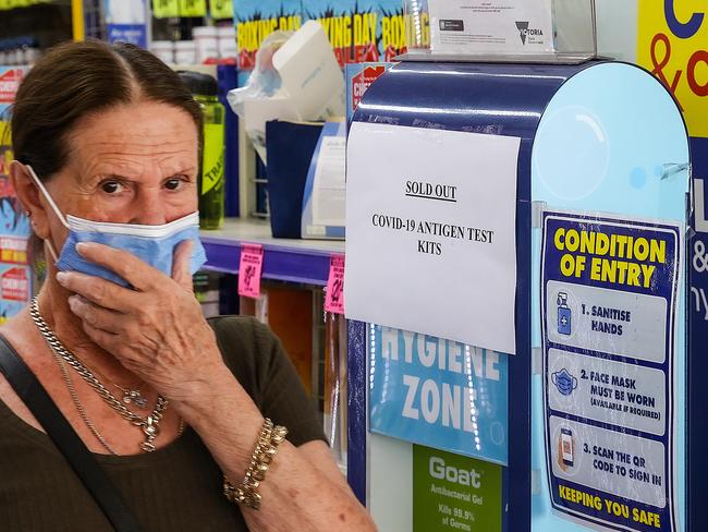 A woman walks past the sold out sign of test kits at Chemist Warehouse in South Melbourne. Picture: Ian Currie