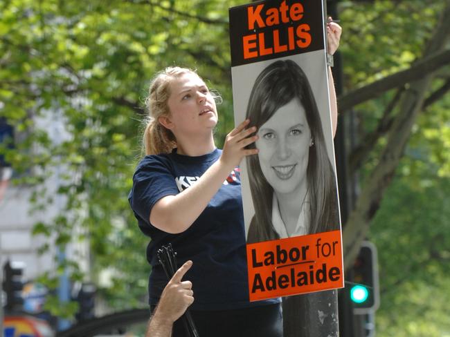 Labor party worker puts up a poster for Kate Ellis in King William Street, Adelaide.