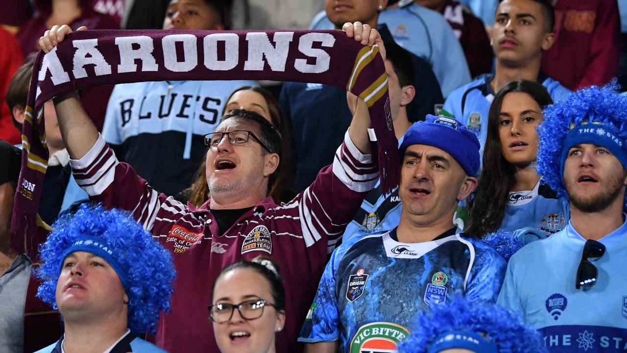 A Queensland fan (left) is seen amongst NSW fans. (AAP Image/Darren England)