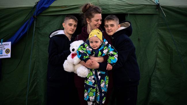 Ukrainian refugee Tetyana Dzymik from a village near Bucha poses with her children, twins Ivan and Danylo, and baby Oleksiy, at the entrance to an NGO tent in eastern Slovakia. Picture: AFP