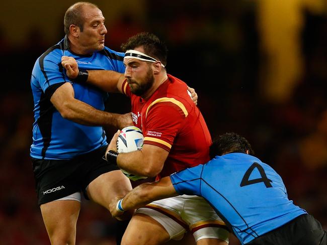 Welshman Scott Baldwin is cut in half by Uruguay defenders.