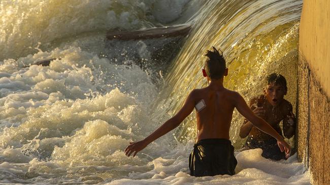 A boy is seen under the flow of water as it hits the Brewarrina Weir in February after years of crippling drought. Picture: Jenny Evans/Getty Images