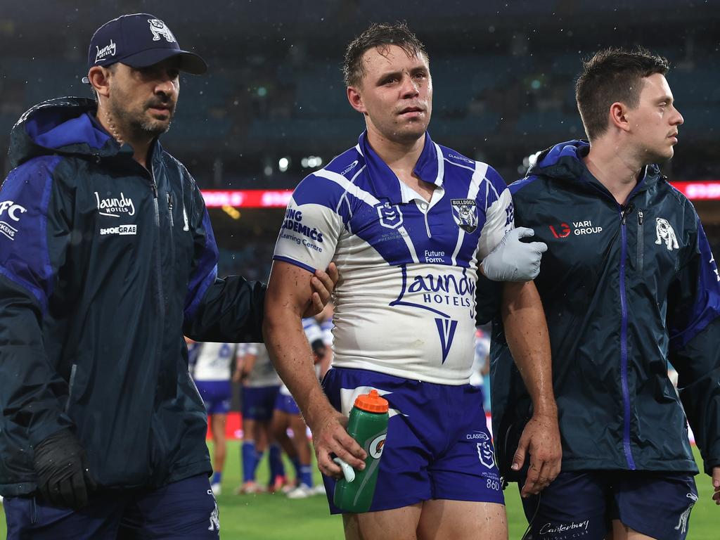 Blake Taaffe of the Bulldogs is assisted off the field by trainers for a Head Injury Assessment. Picture: Cameron Spencer/Getty Images