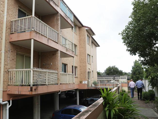 Detectives (right) inspecting the public housing unit block where Sean Froggatt was allegedly murdered. Picture: John Grainger