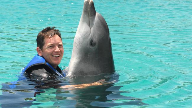 A Sea World dolphin trainer at the Gold Coast theme park with Tuffy the dolphin. Picture: Paul Riley.