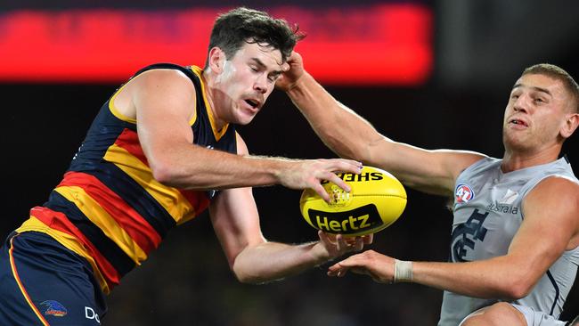 Adelaide’s Mitch McGovern takes a grab ahead Carlton’s Liam Jones on Saturday night. Picture: AAP Image/David Mariuz