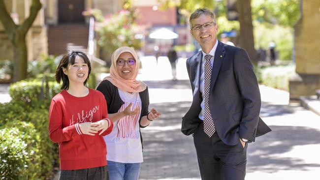 Thai student Panisa Dechwechprasit and Naileh Zainarry of Malaysia with vice-chancellor Peter Hoj at the University of Adelaide on Tuesday. Picture Roy VanDerVegt.