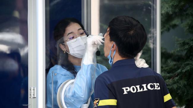 Medical staff test police officers in the South Korean capital of Seoul as the cities active cases have soared by three-digit figures for a week straight. Picture: Getty Images