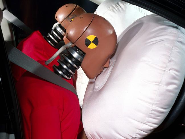 A Holden passenger airbag deploying simultaneously with driver's airbag in crash test dummy safety research experiment.