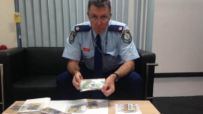 Inspector Jim Szabo with a number of fake counterfeit $50 and $100 notes