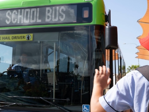 A student waves down a school bus on the Gold Coast.