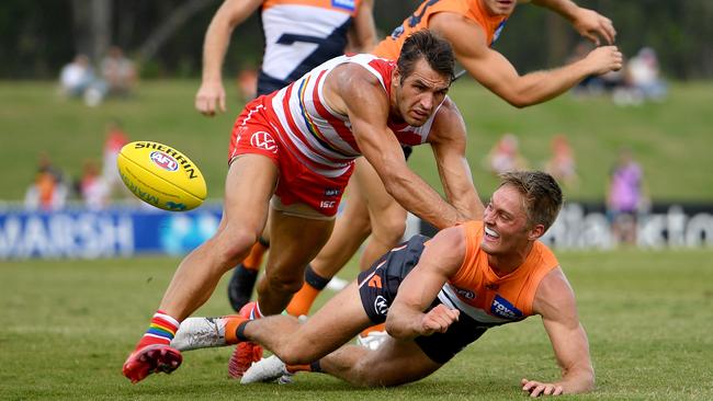 Jackson Hately fires out a handpass in front of Sydney’s Josh Kennedy during the Marsh Series. Picture: Dan Himbrechts/AAP