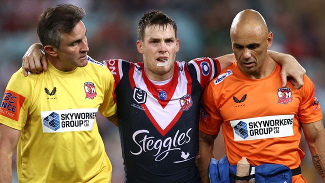 SYDNEY, AUSTRALIA - MARCH 26:  Luke Keary of the Roosters is helped off the field after a leg injury during the round three NRL match between the South Sydney Rabbitohs and the Sydney Roosters at Stadium Australia on March 26, 2021, in Sydney, Australia. (Photo by Cameron Spencer/Getty Images)