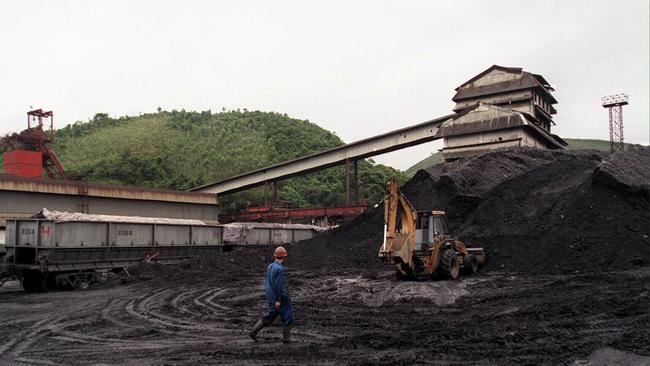 A miner crosses a coal sorting site at a Vietnames coal mine.