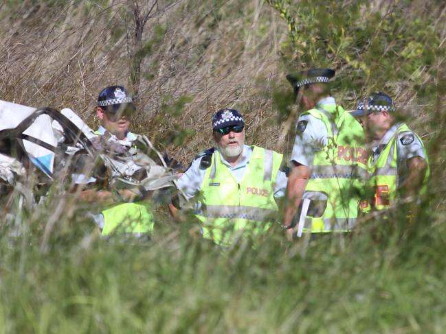 Police officers at the scene of a car crash on the Bruce Highway south of the Caves which killed four people. Picture: Chris Ison/The Morning Bulletin