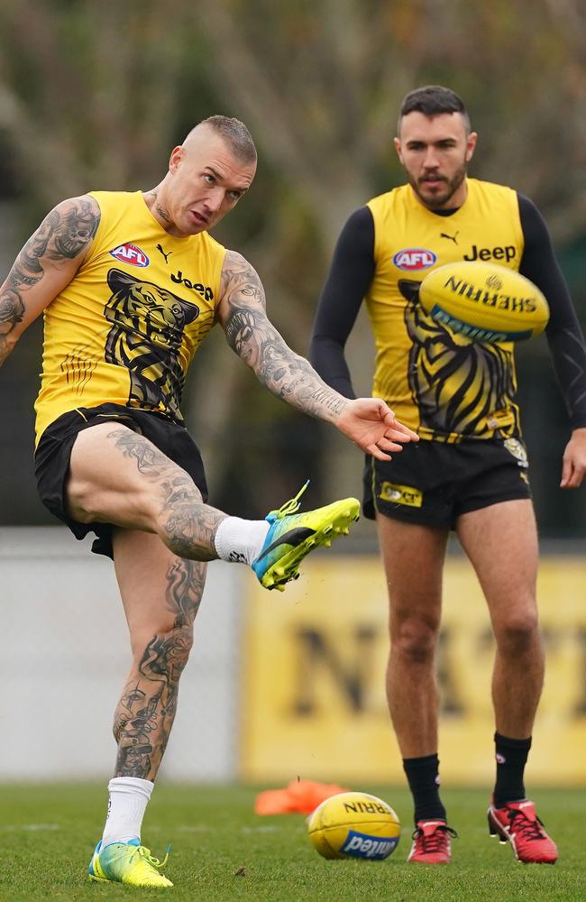 Dustin Martin kicks the ball as Shane Edwards of the Tigers looks on at Punt Rd in 2020. Picture: AAP/Scott Barbour.