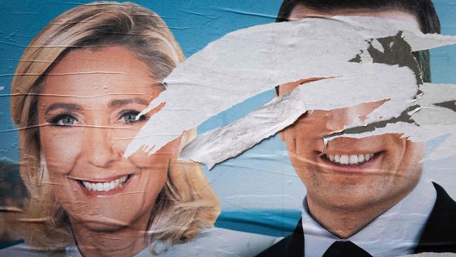 An electoral poster of the French far-right National Rally party with defaced portraits of party President Jordan Bardella (right) and President of the RN parliamentary group Marine Le Pen (left). Picture: Joel Saget/AFP