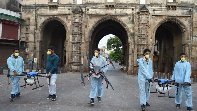 A team carries their drones after spraying disinfectants in Ahmedabad in India last month. Picture: AFP