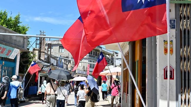 Taiwanese flags on a street lane as tourists walk past in Taiwan's Kinmen islands. Picture: AFP