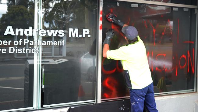 A cleaner removes graffiti from Daniel Andrews' electoral office at Noble Park. Picture: NCA NewsWire / Andrew Henshaw