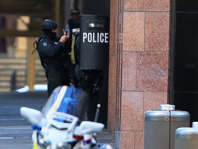 The heavily-armed officers waiting outside the cafe during the siege. Picture: Toby Zerna