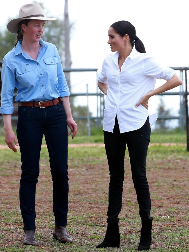 Meghan Markle (right) wearing the jeans as she chats to Laura Woodley in Dubbo. Picture: Toby Zerna