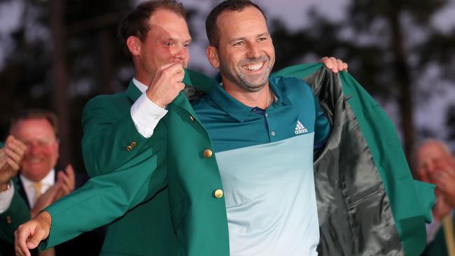 Danny Willett of England presents Sergio Garcia of Spain with the green jacket.