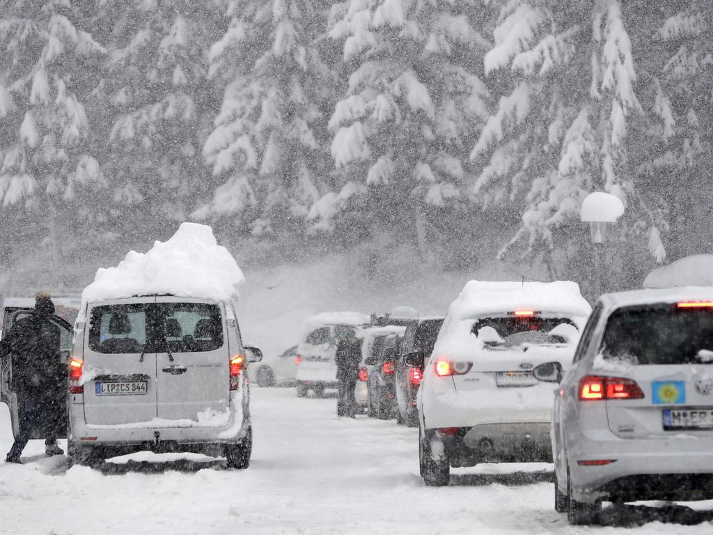 Tourist cars queue on the main road out of a valley that was blocked after heavy snow falls in Austria. Picture: AP Photo/Matthias Schrader