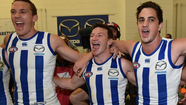 Join in the chorus: Taylor Garner (right) belts out the song with Brent Harvey and Drew Petrie following the 2015 elimination final. Picture: AAP Image/Julian Smith